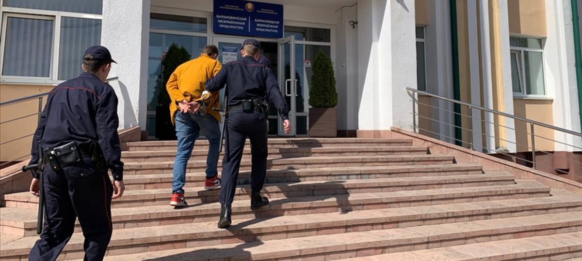 Милиционеры ведут задержанного мужчину в Барановичскую межрайонную прокуратуру
